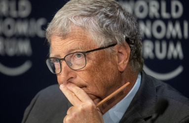 El empresario Bill Gates con su mano izquierda en su barbilla y sostiene un lápiz. 