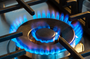 Gas ardiendo con llamas azules en el quemador de una estufa 