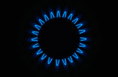 Quemador de estufa encendido con llama azul 