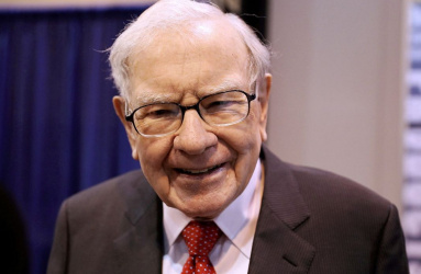 Empresario Warren Buffett sonriendo, viste traje y corbata. 