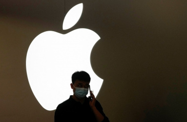 El icono de la marca Apple con luz blanca y la sombra de una persona hablando por celular. 