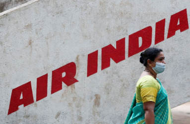 Mujer caminando junto a letrero de Air India