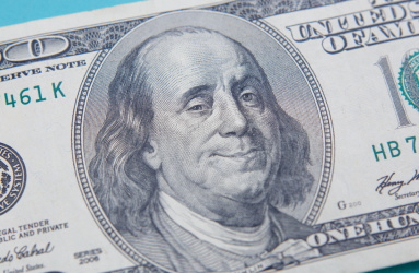 Billete de 100 dólares con Benjamin Franklin sonriendo.