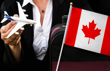 Mujer con un avión de juguete en mano y una bandera de Canadá del otro lado