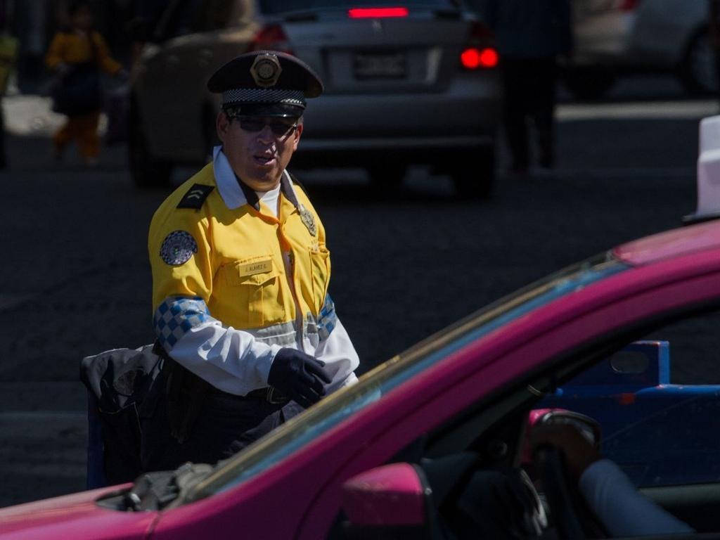 Un policía de tránsito detiene a un automóvil para levantar una infracción. 