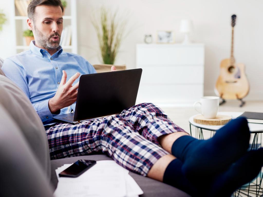 Una persona utiliza camisa y pijama, mientras habla frente a una laptop. 