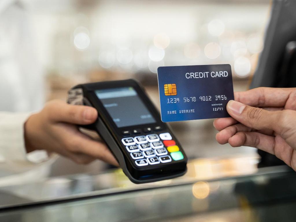 Persona sostiene terminal punto de venta para pago con tarjeta 