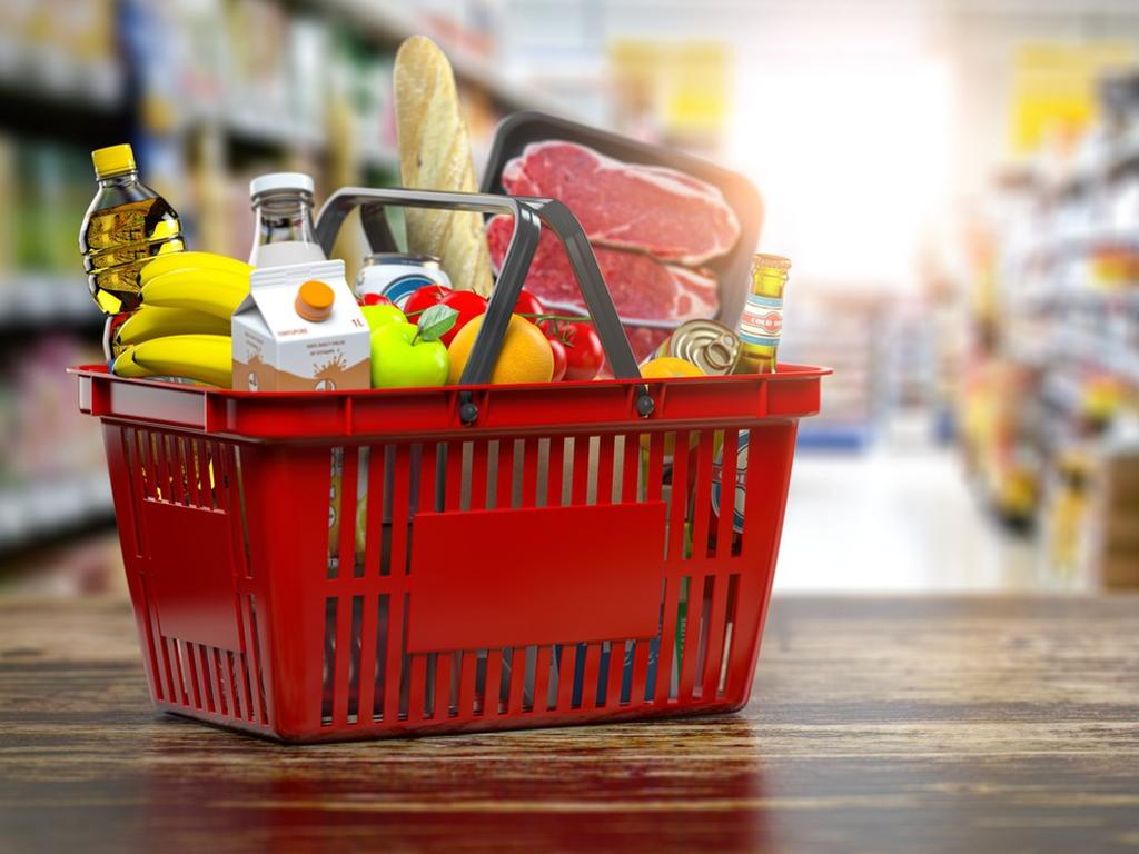 Una canasta de supermercado contiene productos básicos tales como leche, carne, aceite, entre otros. 