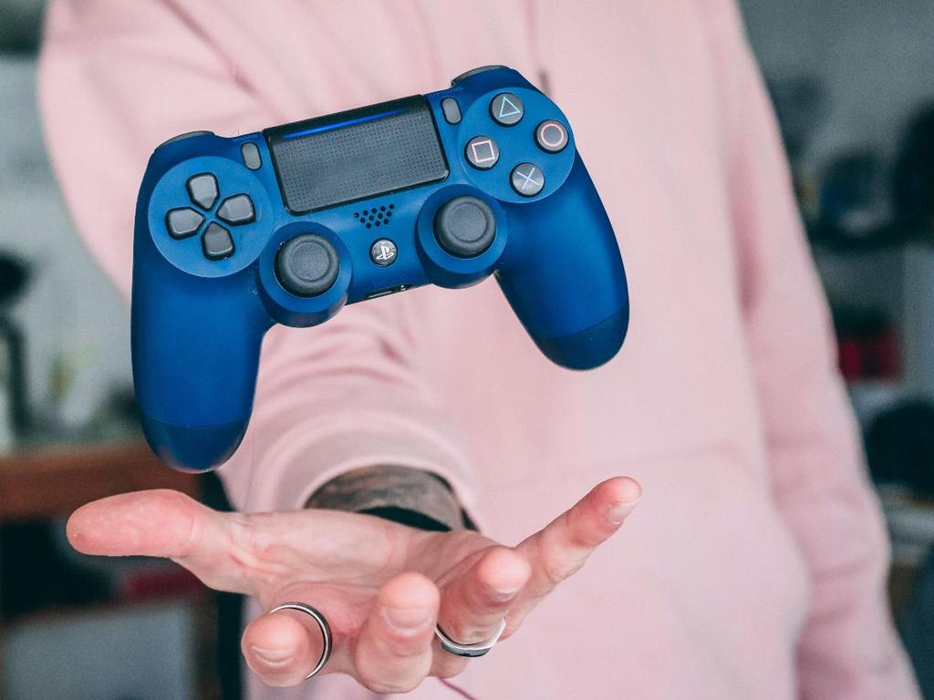 Joven con control de videojuegos color azul 