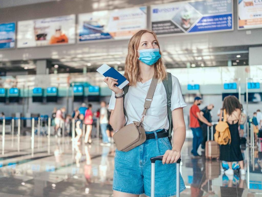 mujer en aeropuerto con maleta y boleto
