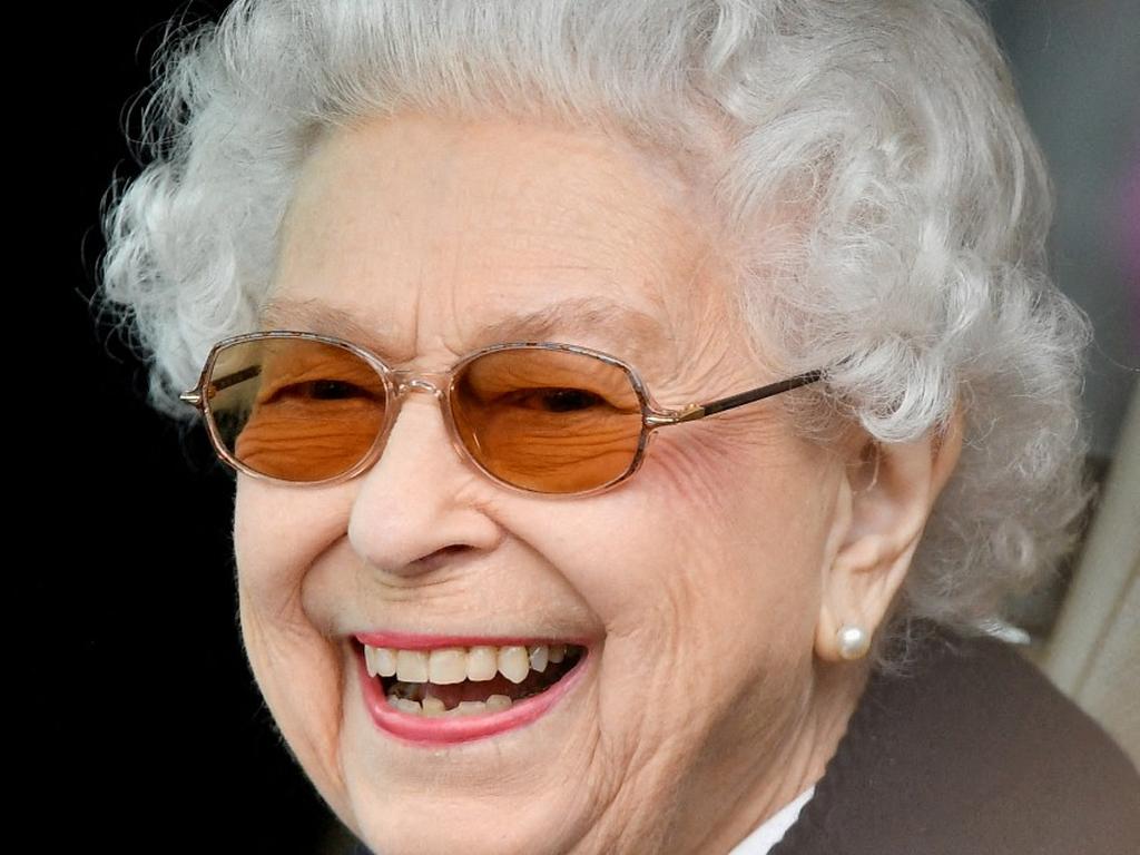 La reina Isabel II sonríe de perfil frente a la cámara. 