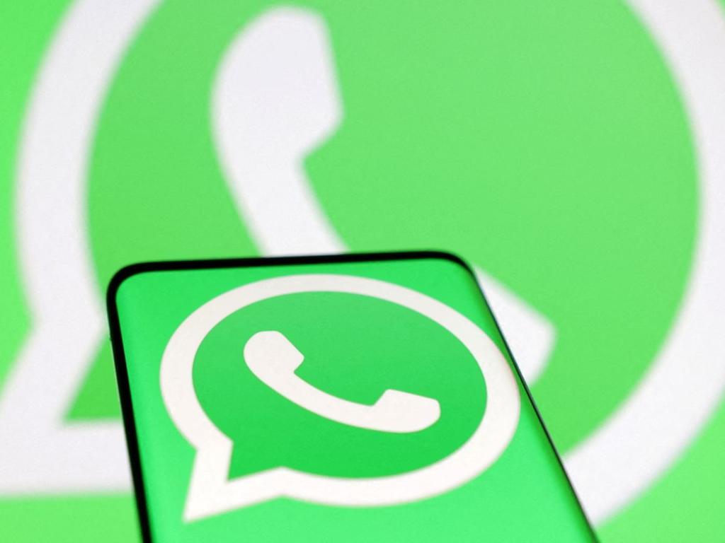 celular con logo de whatsapp y logo de whatsapp de fondo