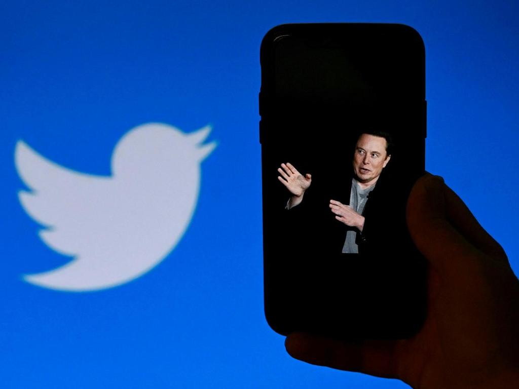 Elon Musk en la pantalla de un celular y logo de Twitter 