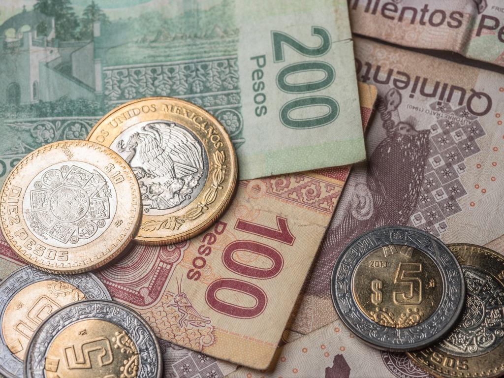 Billetes de 500, 200 y 100 pesos mexicanos, amontonados con monedas de 5 y 10 pesos. 