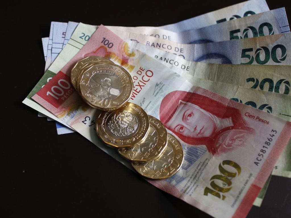 Monedas de 20 pesos mexicanos sobre billetes 