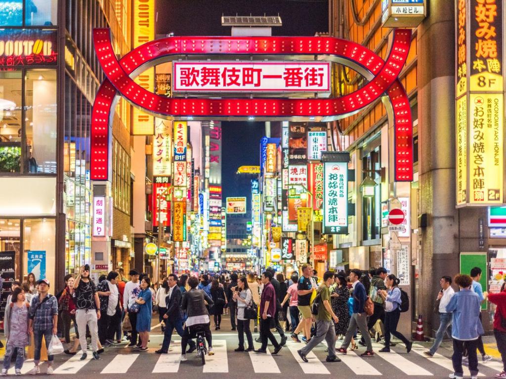 Japoneses caminando en calles de Tokio en la noche
