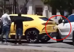 Ben Affleck y una persona parados frente a un Lamborghini chocado