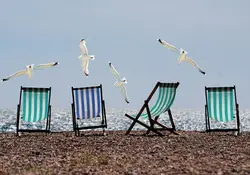 Cuatro sillas de playa frente al mar