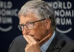 El empresario Bill Gates con su mano izquierda en su barbilla y sostiene un lápiz. 