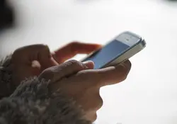 Mujer sostiene con las manos teléfono iPhone