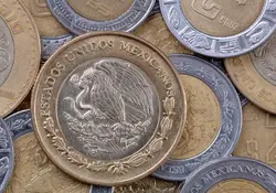 Moneda de 10 pesos sobre otras monedas 