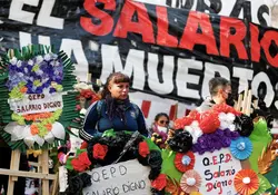 Dos argentinos protesta con letrero de salario ha muerto