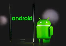 Figura de Android color verde junto a smartphone negro 