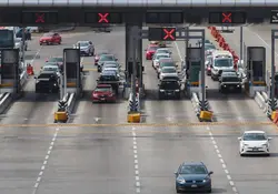 Varios autos atraviesan la caseta de una autopista en México. 