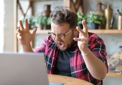 Hombre gritando frente a computadora