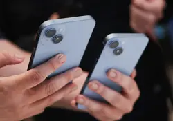 Unas manos sostienen dos dispositivos del iPhone 14. 