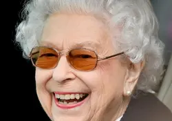 La reina Isabel II sonríe de perfil frente a la cámara. 