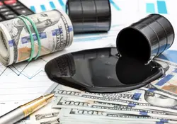 Barril de petróleo derramado sobre billetes 100 dolares