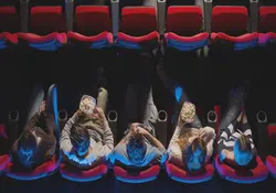 personas sentadas en fila de sala de cine
