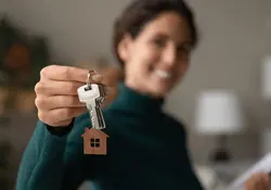 Mujer sosteniendo llaves de una casa 