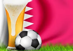 Animación de un vaso de cerveza y un balón de futbol sobre el pasto, la bandera de Qatar al fondo. 