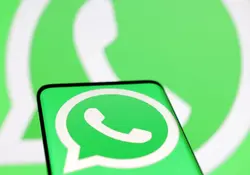 celular con logo de WhatsApp y de fondo el logo de WhatsApp
