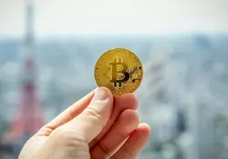 Mano sostiene un bitcoin 