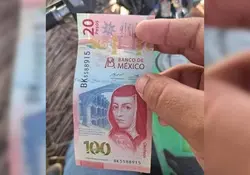 Manos sostiene billete de 120 pesos 