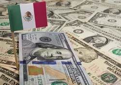 Bandera de México sobre montón de dólares 