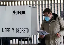 Hombre emite su voto en una casilla del INE 