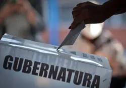 Persona deposita su voto en la urna 
