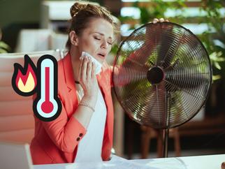 Mujer con calor sentada junto a un ventilador