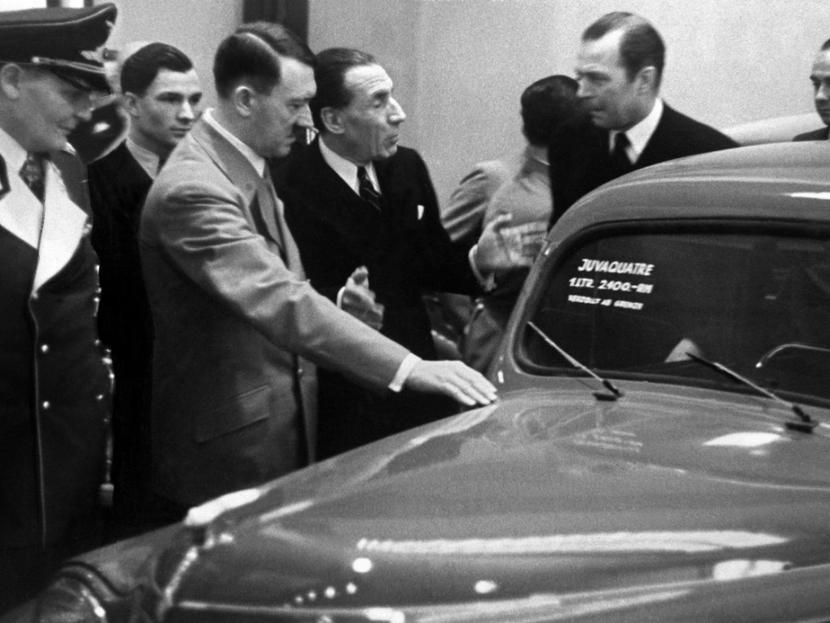 Louis Renault muestra un modelo a Adolf Hitler durante la feria del automóvil de Berlín. Foto: Getty