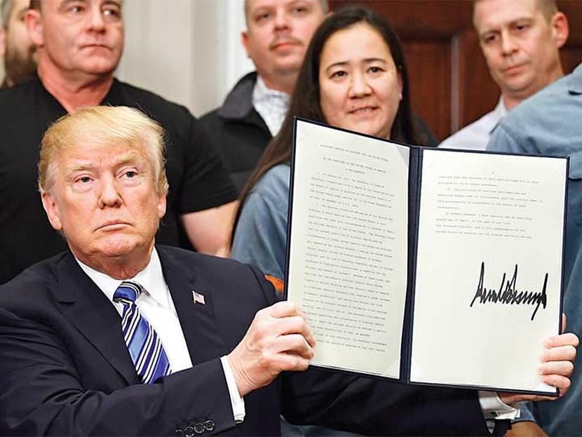 El presidente de EU, Donald Trump, sostiene el documento firmado que promulga los aranceles al acero. También firmó uno para el aluminio. Foto: AP