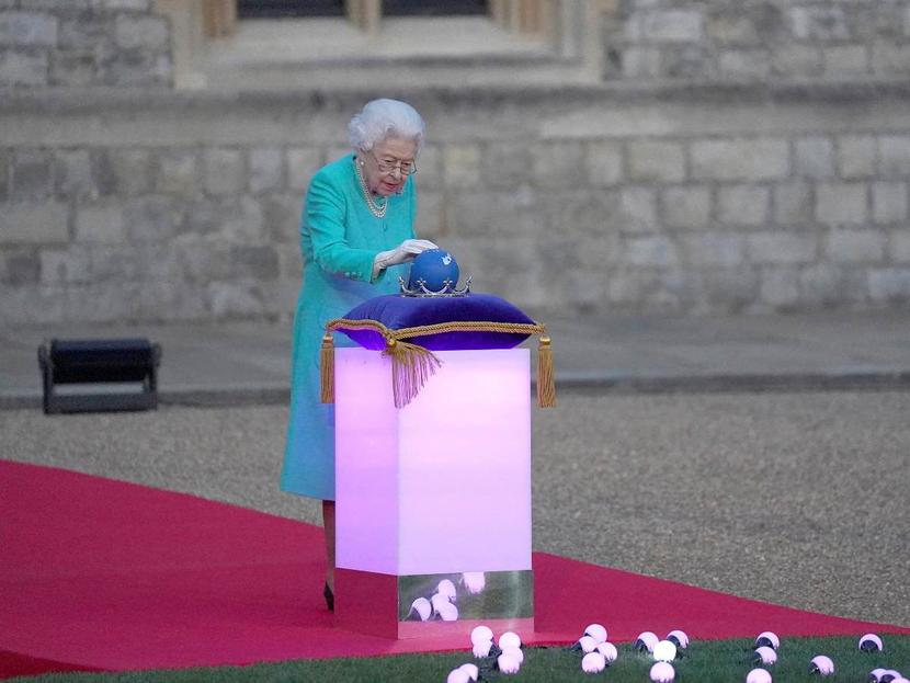 La reina Isabel II tocando la corona 