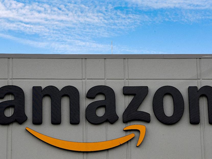 Logotipo de Amazon sobre un edificio y el cielo despejado en el fondo. 