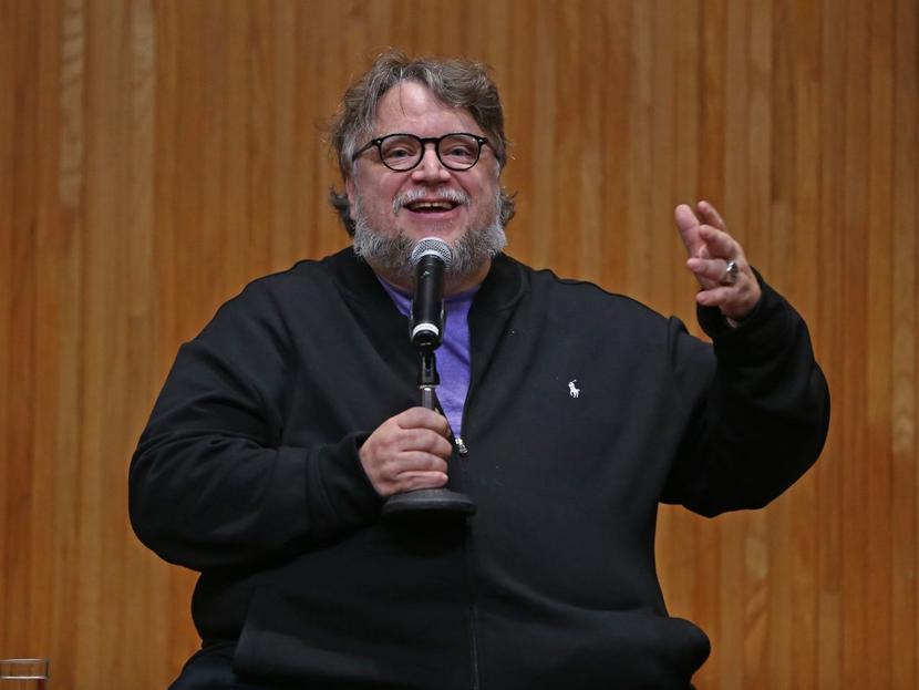 El cineasta Guillermo Del Toro sonríendo mientras habla por micrófono. 