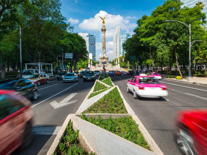 El monumento del Ángel de la Independencia y el camellón de la avenida Paseo de la Reforma, a los costados circulan autos. 