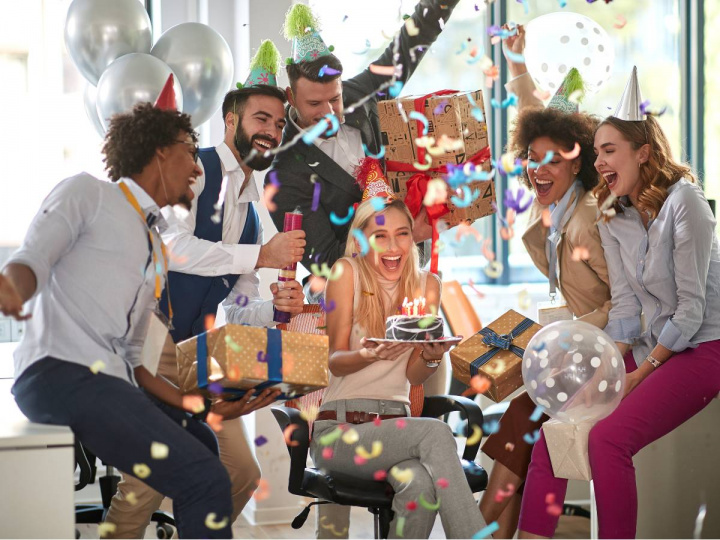 Personas festejando un cumpleaños con confeti y regalos 