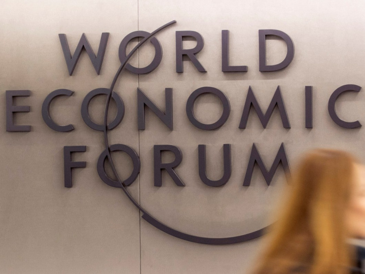 Letras del Foro Económico Mundial sobre una pared y el cabello de una mujer. 